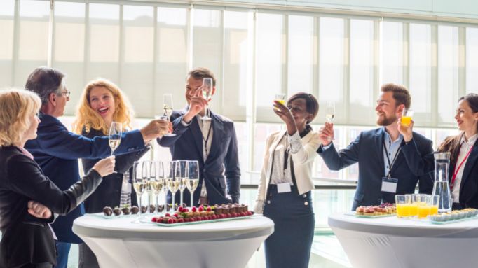 Group of professionals toasting with drinks at a mobile bar setup