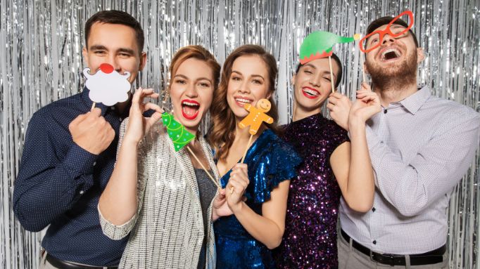Group of people posing with festive photo props