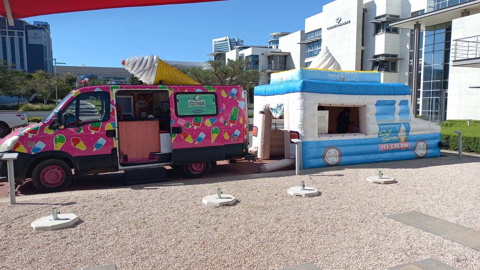 Colorful ice cream truck and inflatable ice cream stand