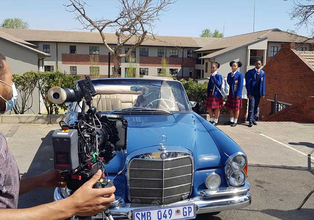 A classic 1958 Mercedes Ponton during a photo shoot with a film camera.