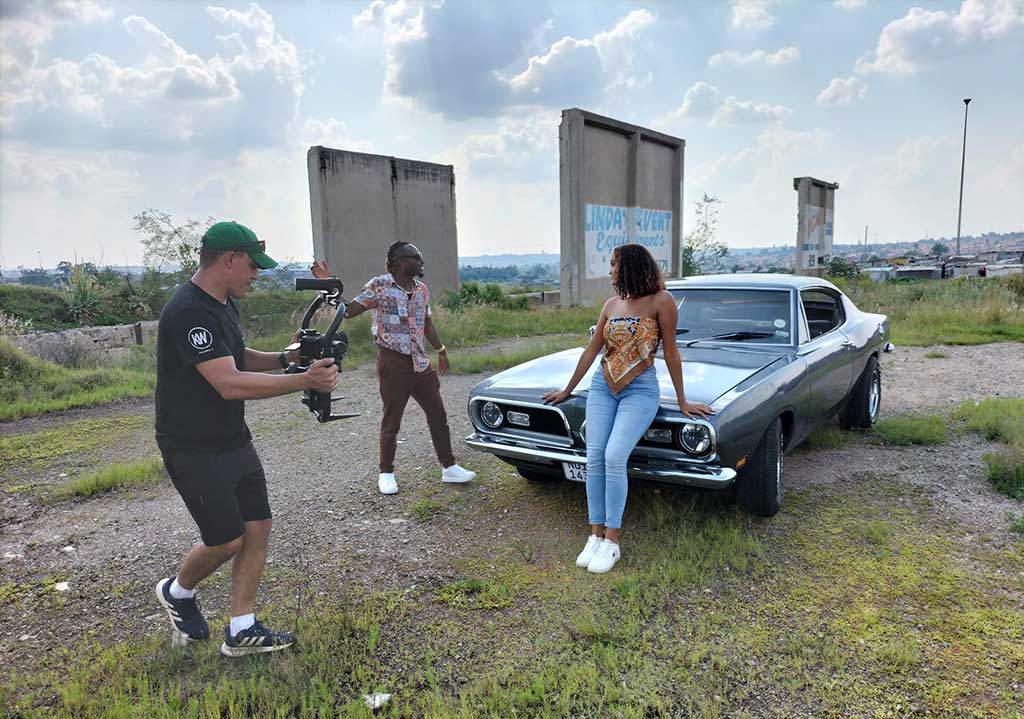 Model posing with a vintage car during a photoshoot