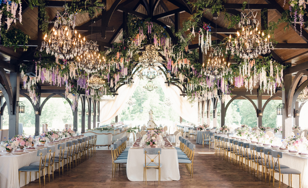 Elegant wedding reception with floral decorations and a long banquet table.