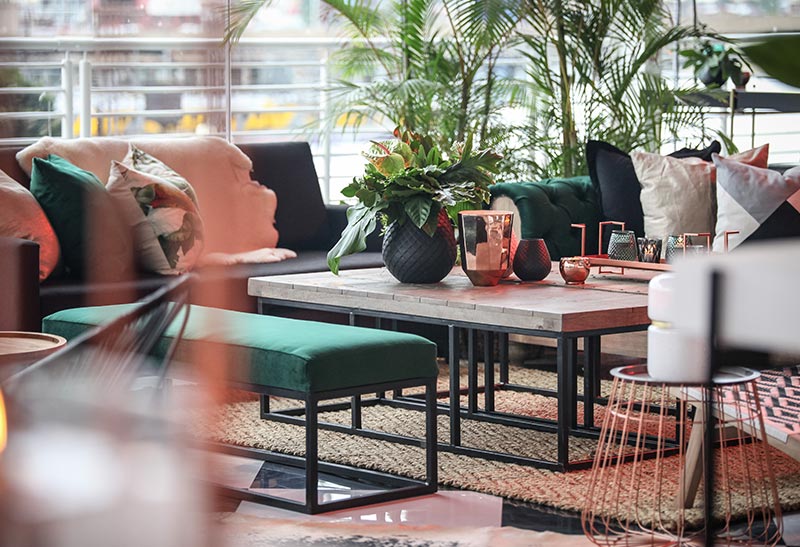 Stylish lounge area with green seating and decorative plants