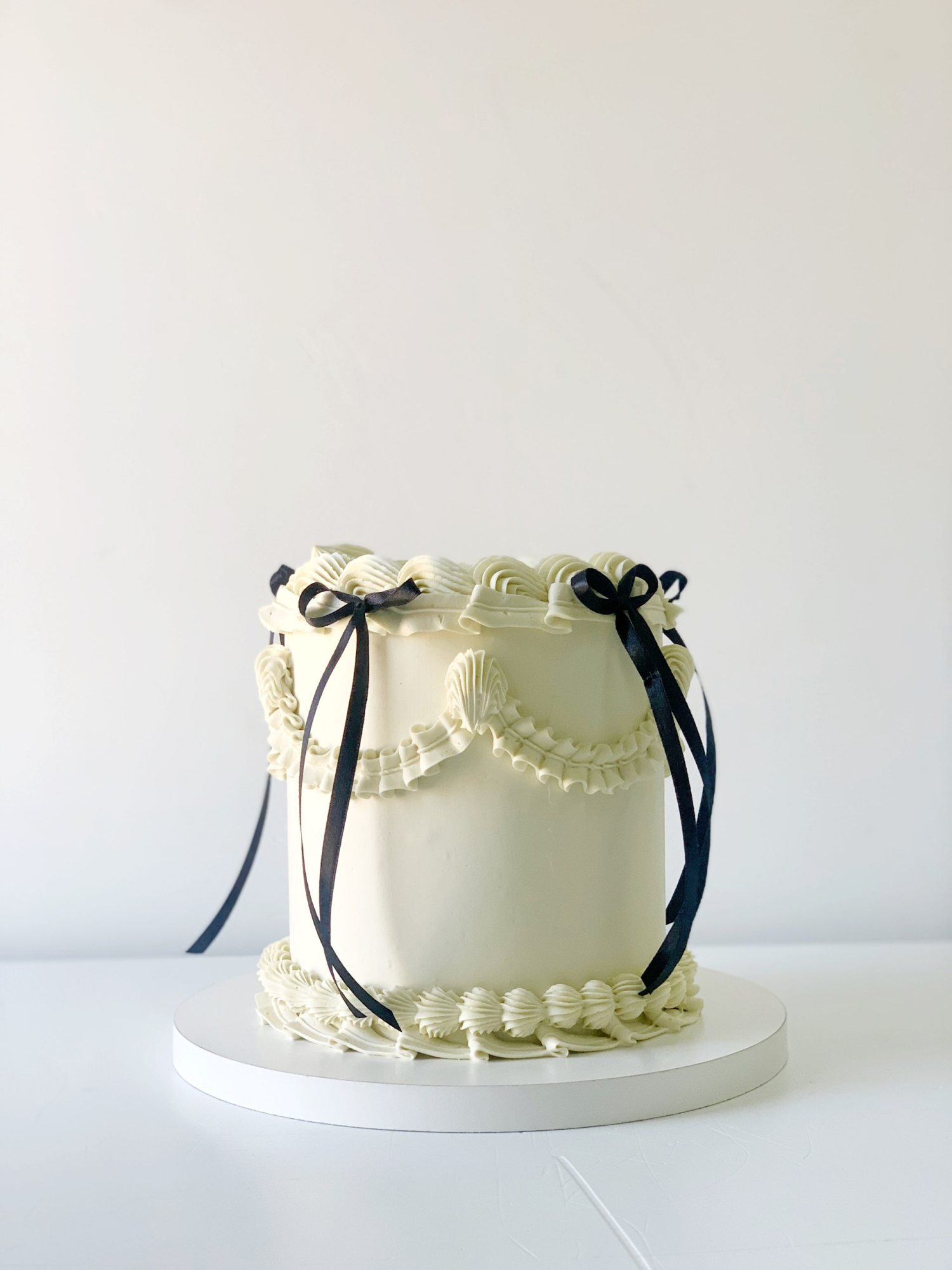 Sophisticated white tiered cake with black ribbons