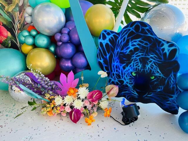 Colorful balloons and flowers in a boho setup.