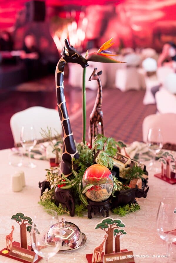 Table centerpiece with wooden giraffes and flower arrangement
