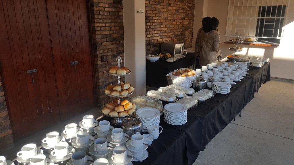 Buffet table with plates, cups, and food displayed