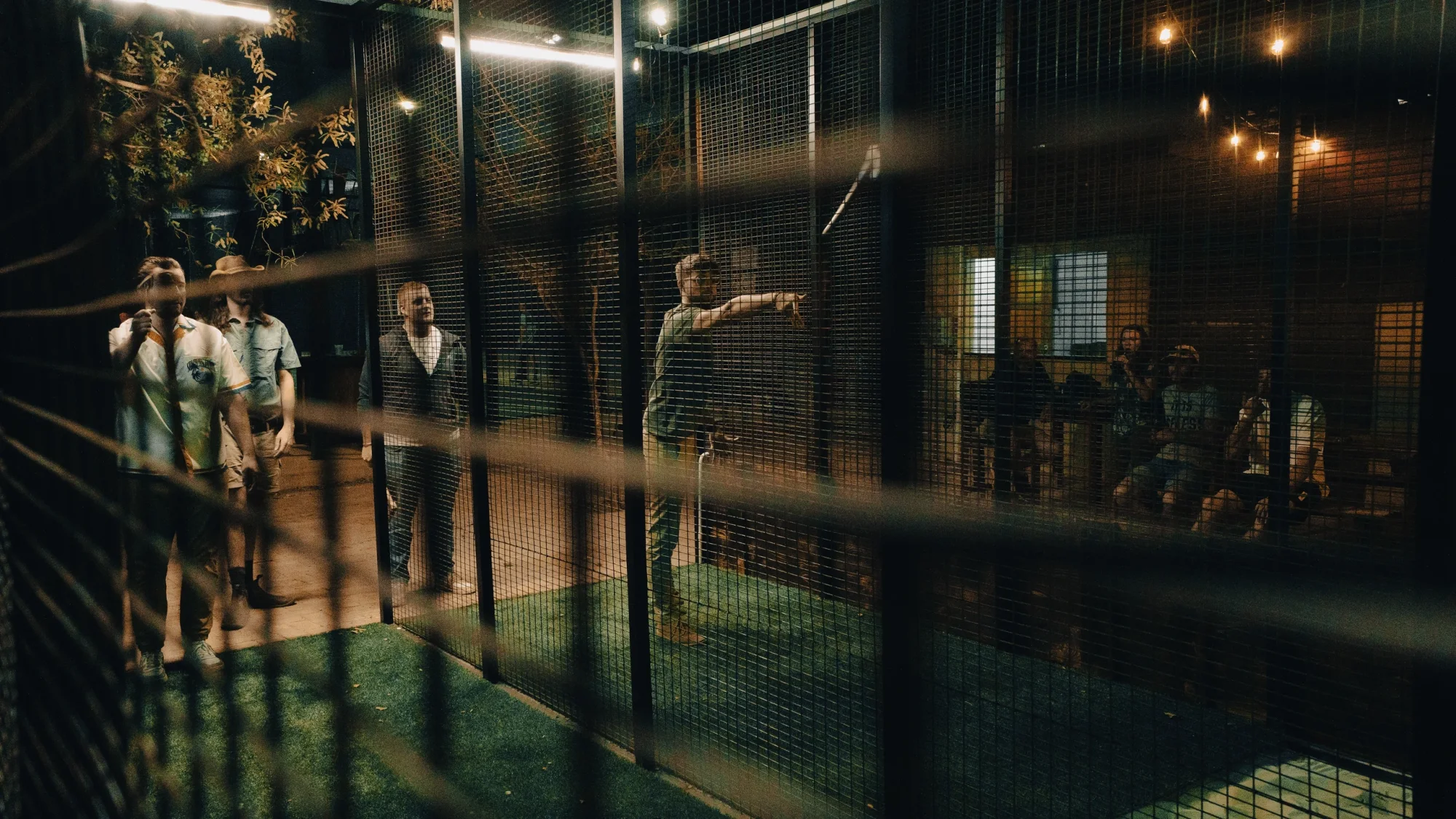 Participants throwing axes in a lit axe throwing venue