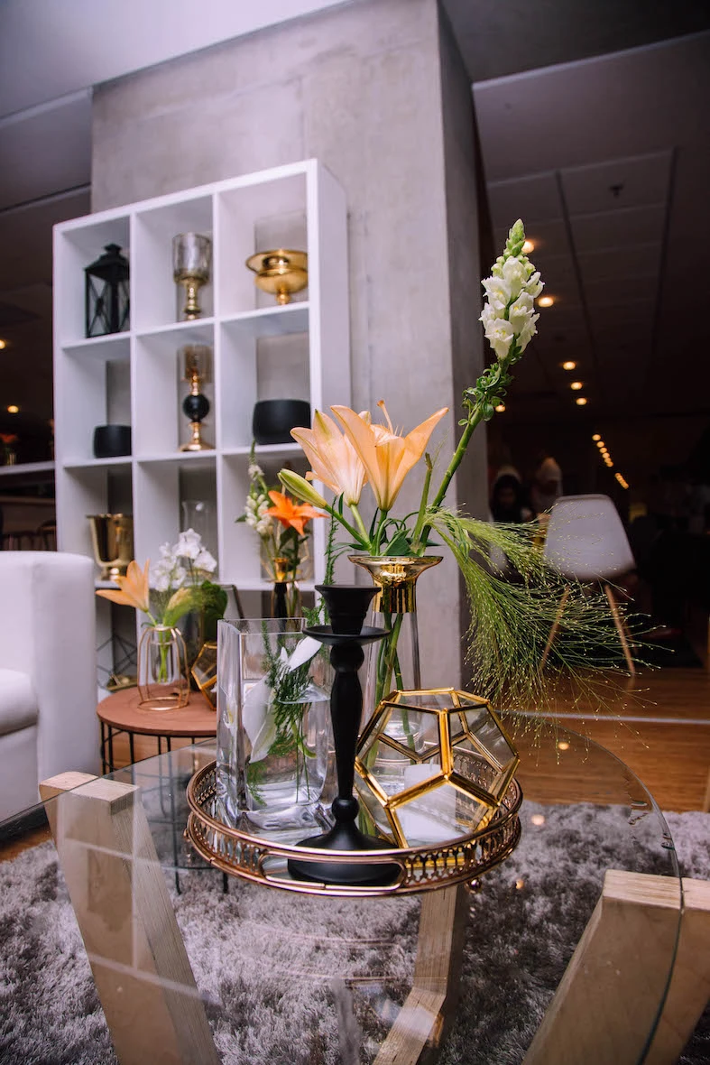Floral centerpiece on a glass table with decor items