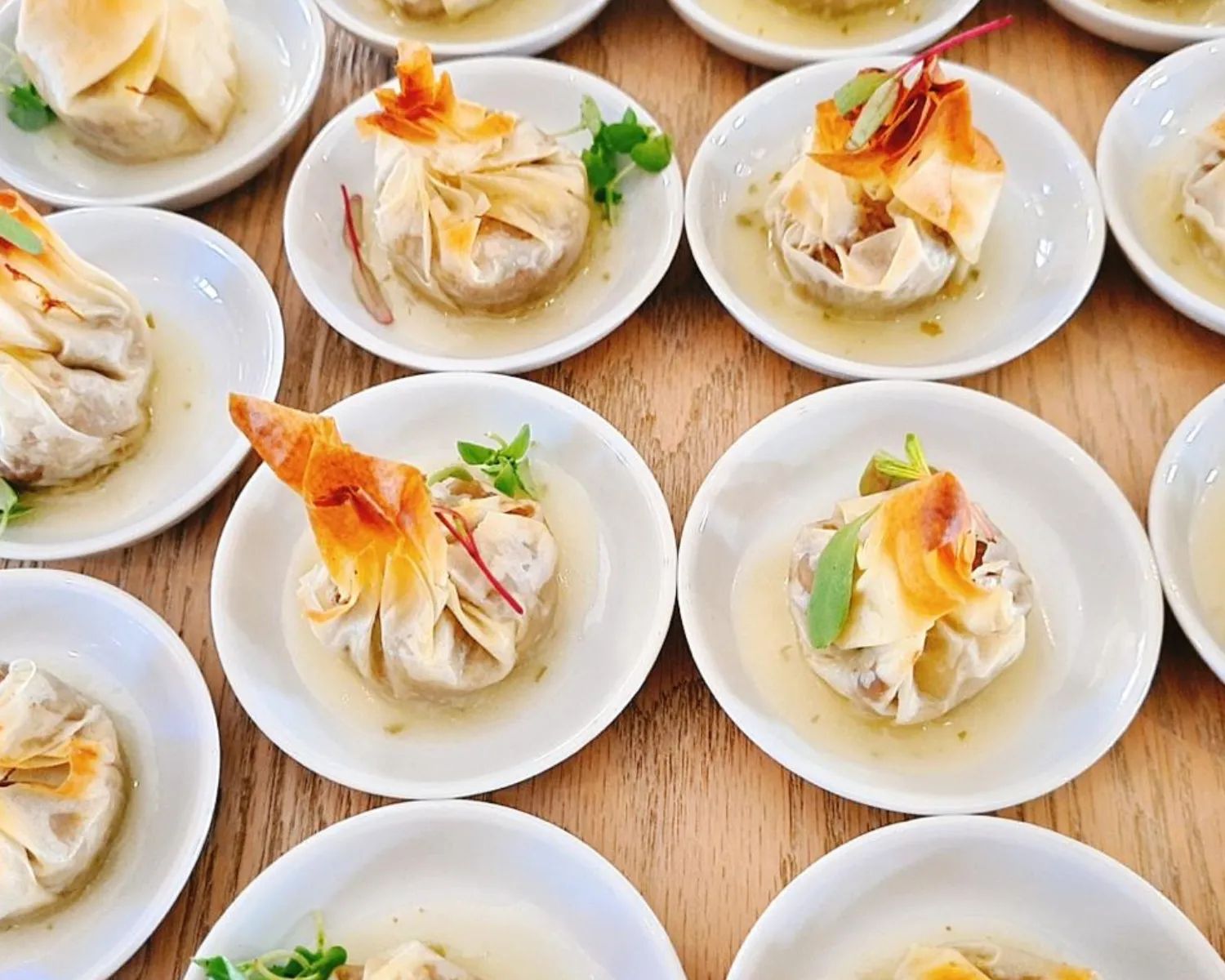 Mini dumplings arranged on plates with garnishes