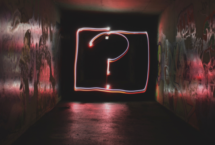 A glowing question mark in a dark tunnel