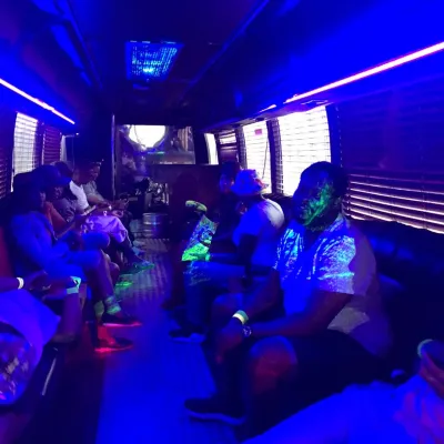 Interior view of a lit party bus with seated guests