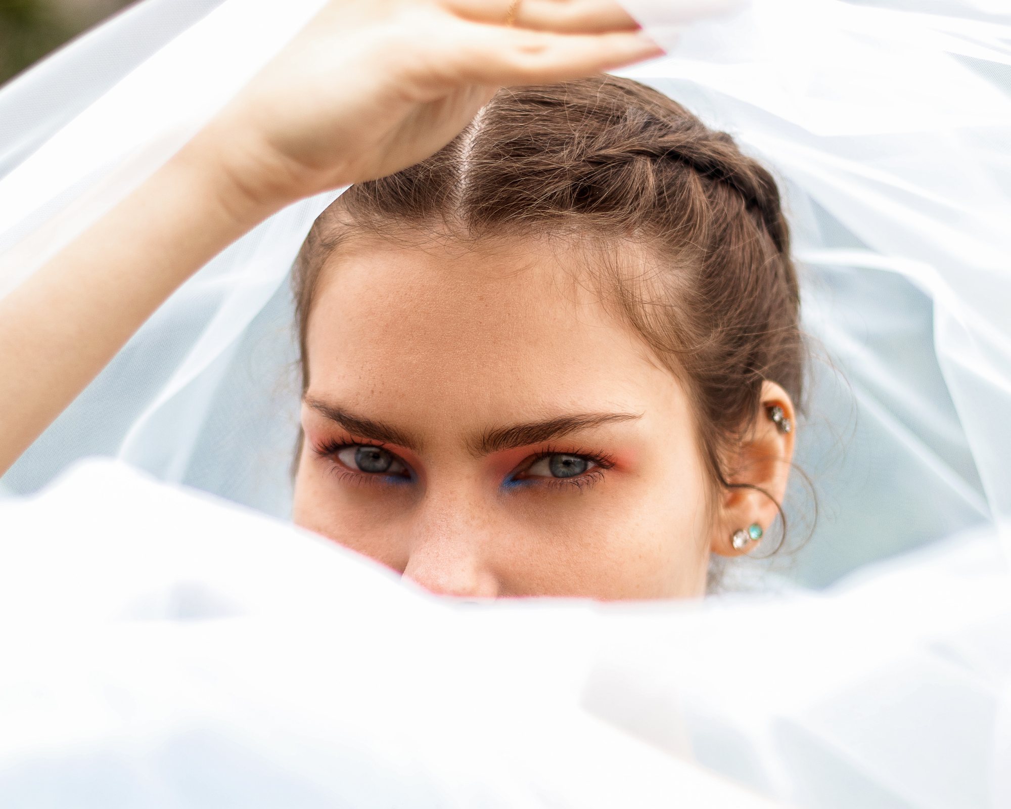 Close-up of a model with bridal makeup under a veil