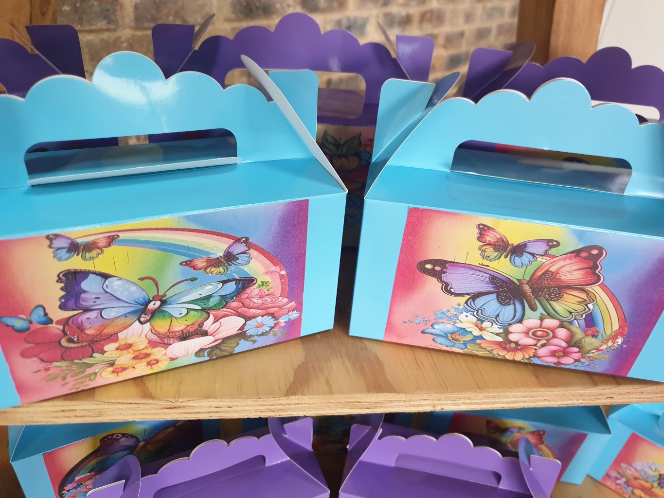 Colorful butterfly-themed party favor boxes on a shelf