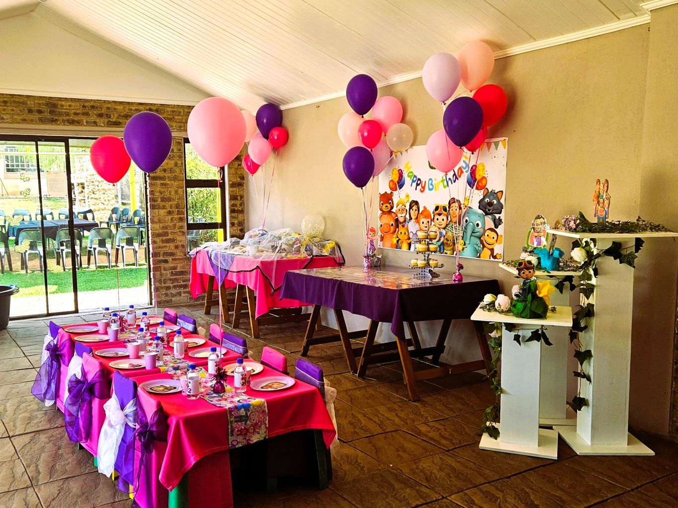 A decorated party venue with colorful tables, balloons, and themed decor.