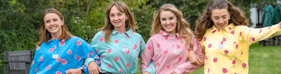 Four children wearing strawberry-patterned outfits