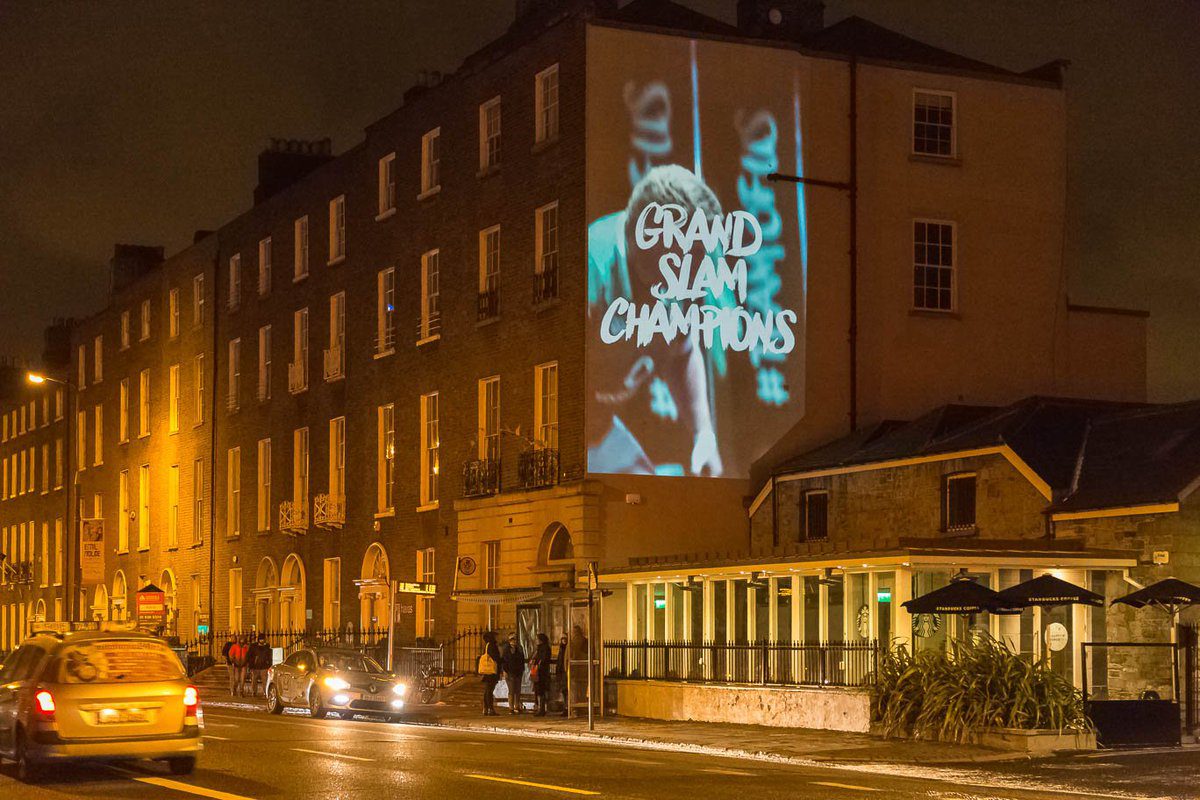 Building projection displaying 'Grand Slam Champions' on a wall