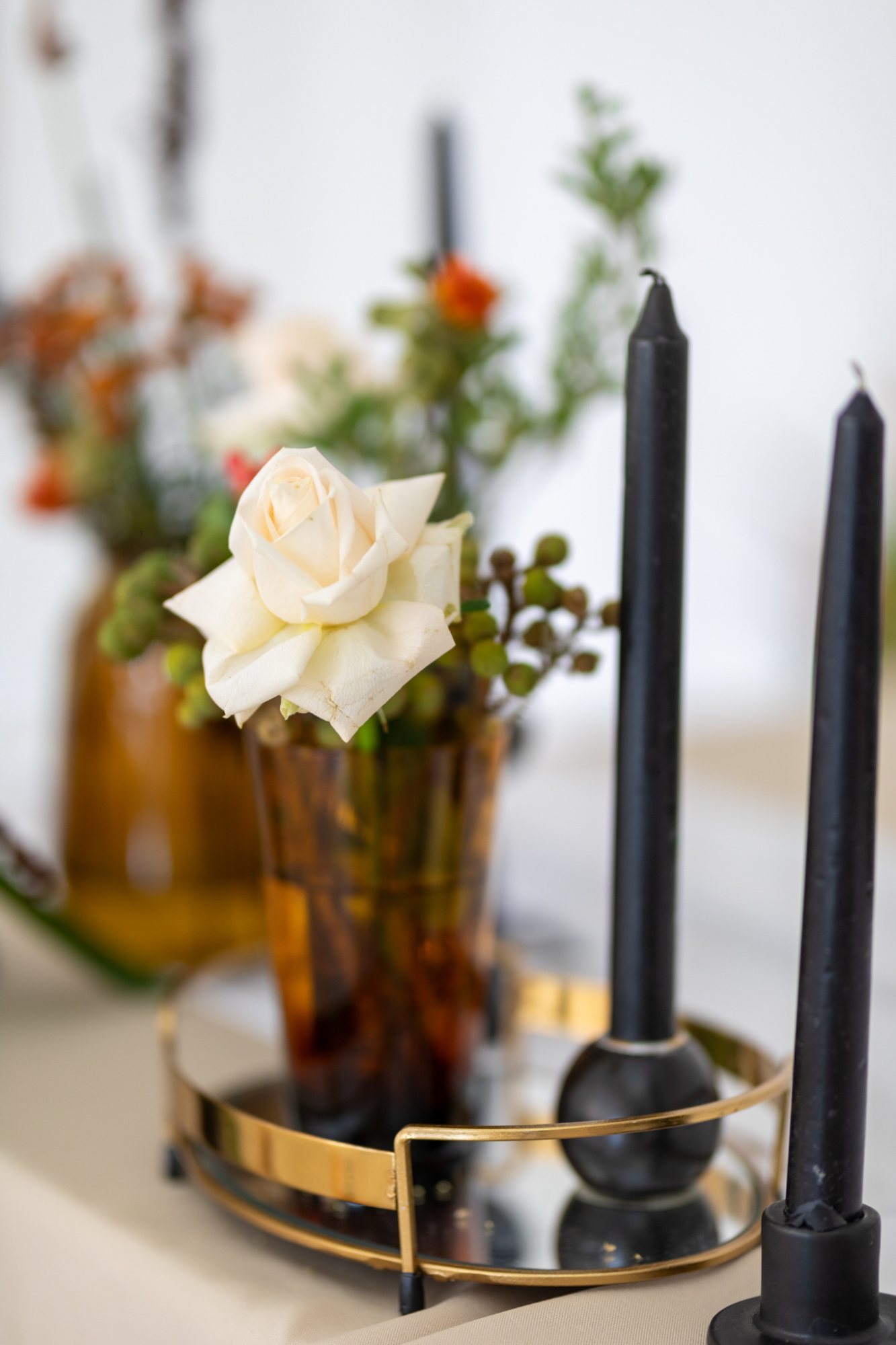 Floral centerpiece with a white rose and black candles