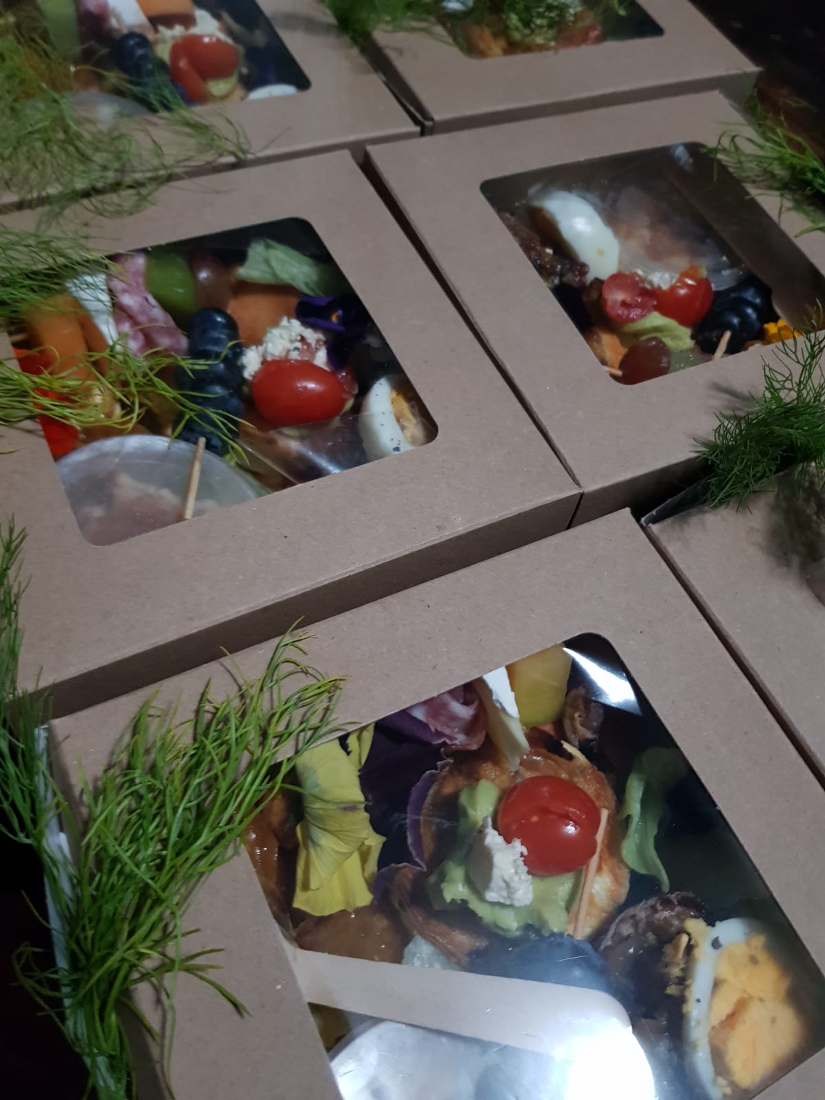 Grazing boxes with various gourmet items and fresh ingredients.