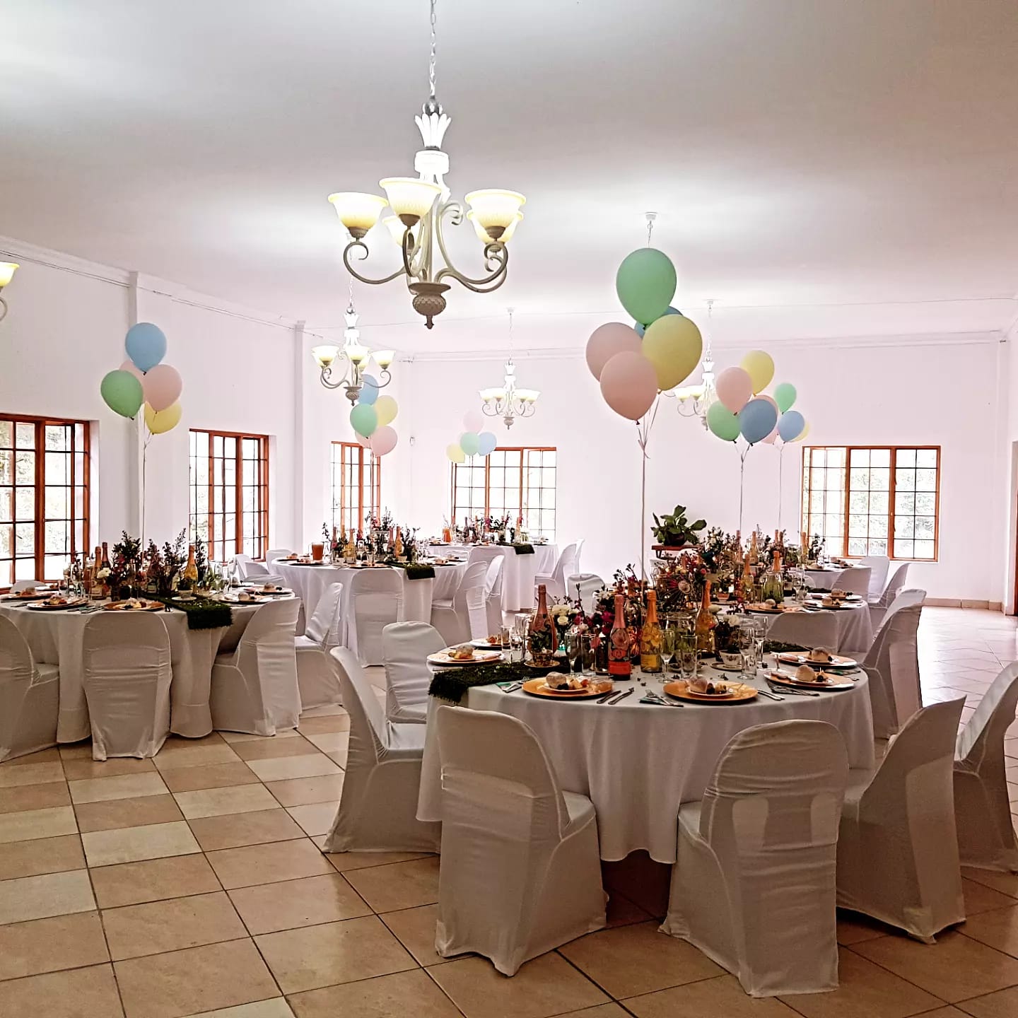 Decorated tables with pastel balloons in a light-filled venue
