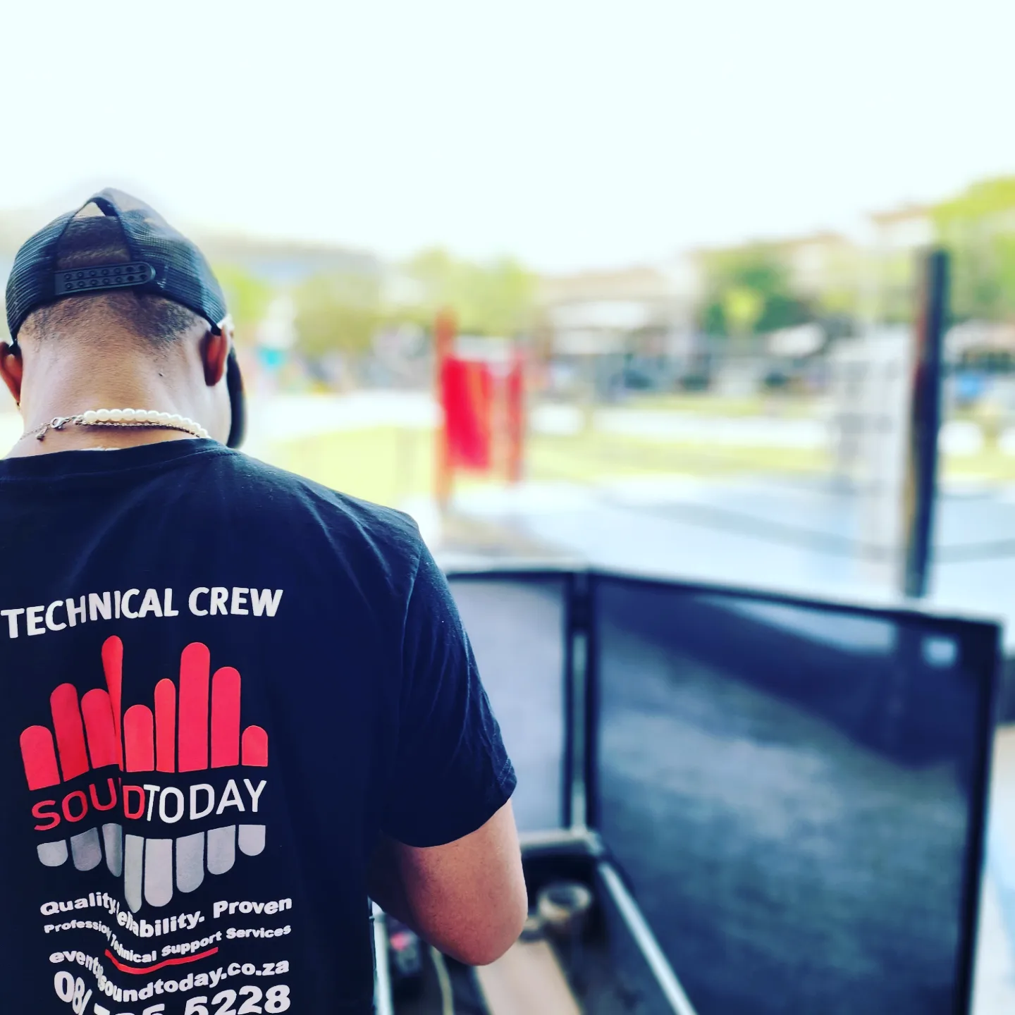 Technician wearing a SoundToday branded shirt overseeing event setup.