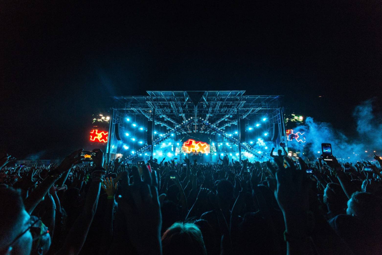 LED screen setup at a vibrant event with audience hands raised