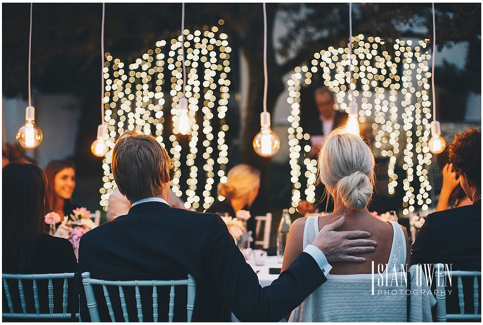 Twinkling fairy lights and elegant bulbs enhance an outdoor event setup.