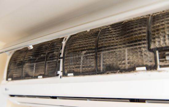 A close-up of a dirty air conditioning unit filter.