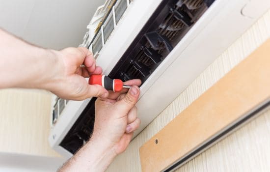 Technician repairing air conditioning unit