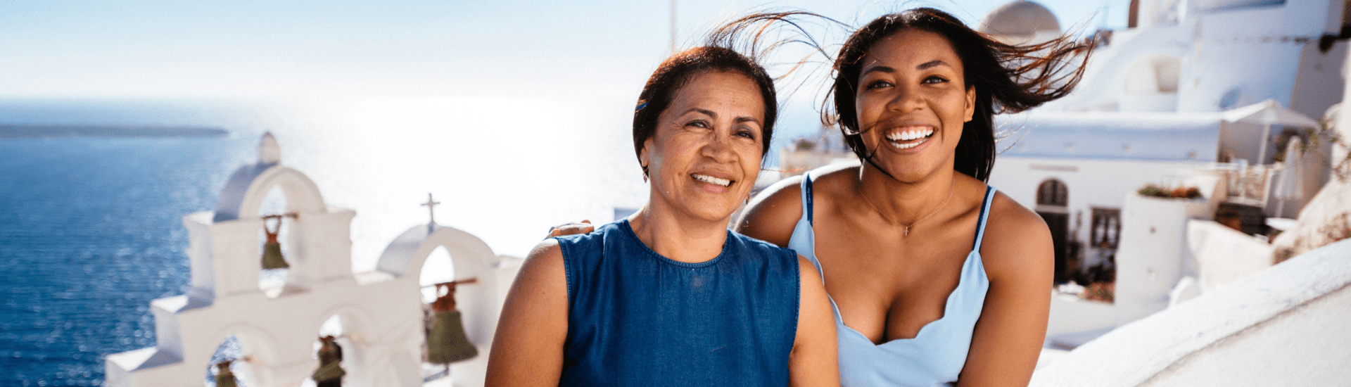 A woman and a girl smiling together outdoors