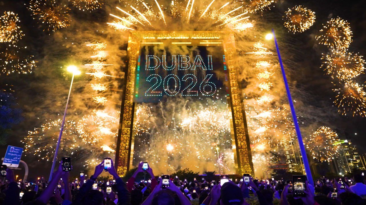 A dazzling drone and fireworks display over a cityscape.