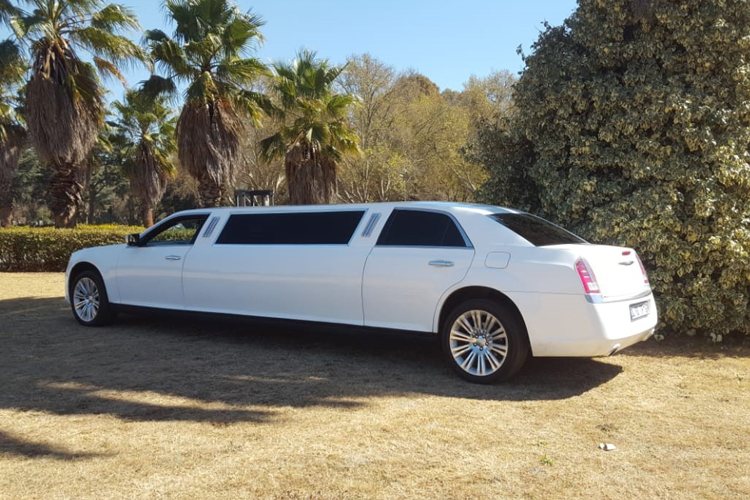 White Chrysler 300 C Limousine parked in a garden.