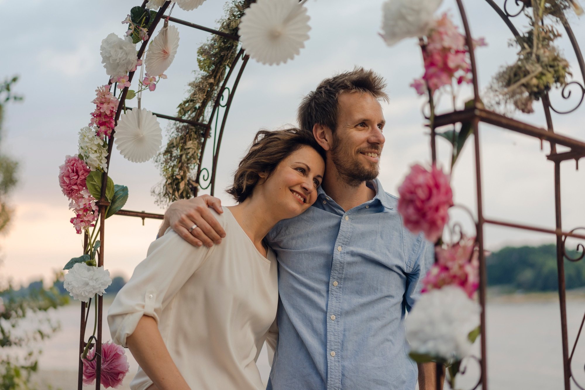 Couple standing under a floral archway