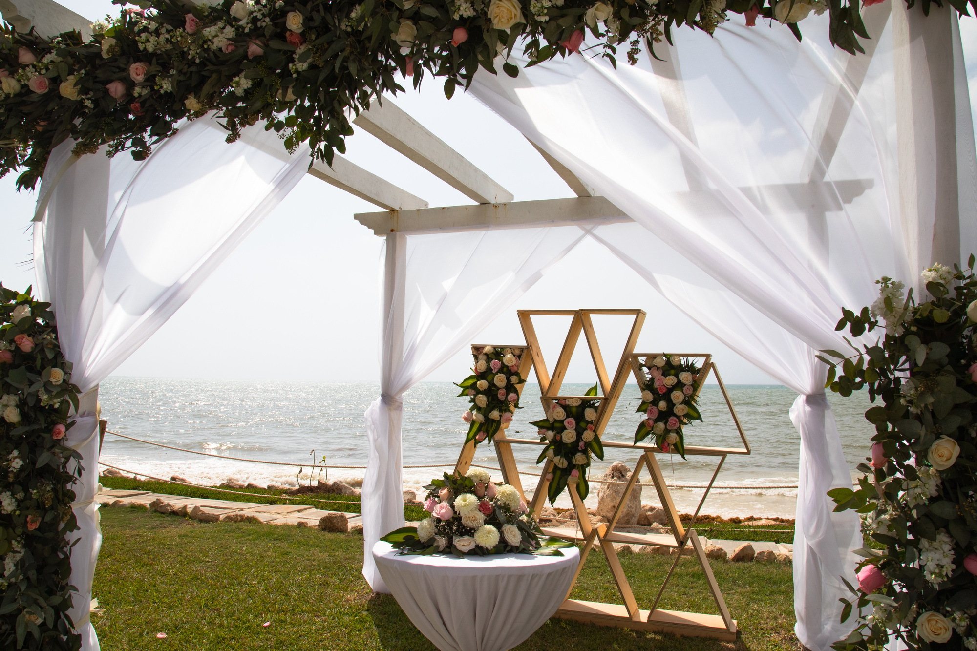 Floral wedding arch with ocean backdrop