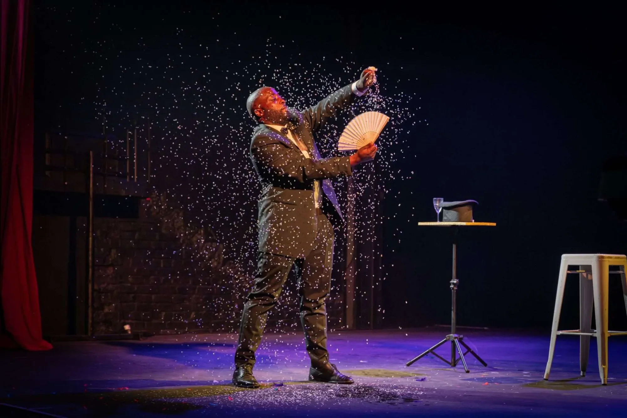 Magician performing with sparkling effects on stage.