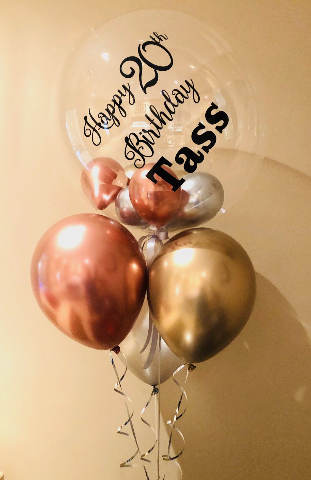 Personalised birthday balloon bouquet with clear orb and metallic balloons.