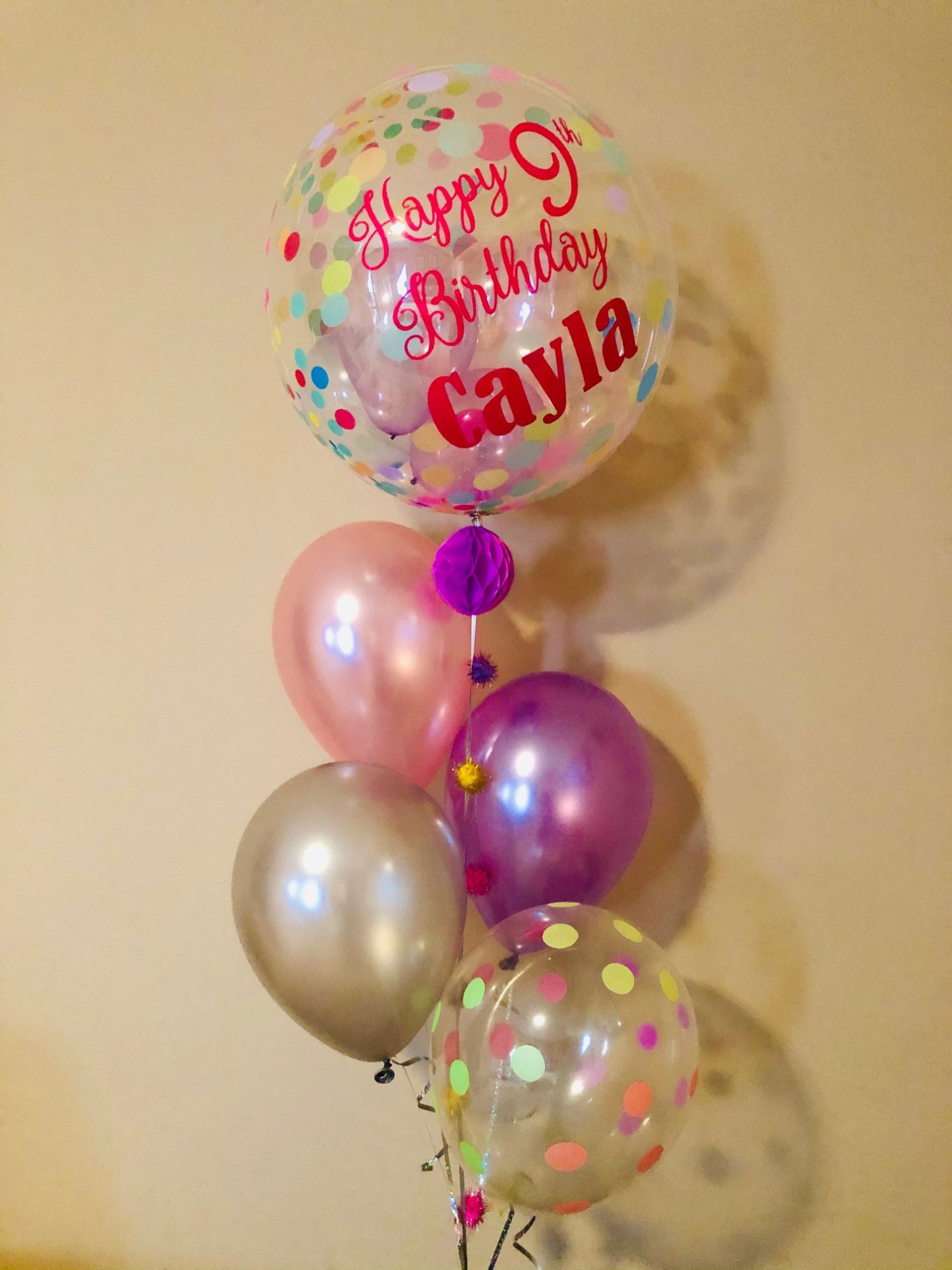 Personalized birthday balloon bouquet with colorful balloons and confetti