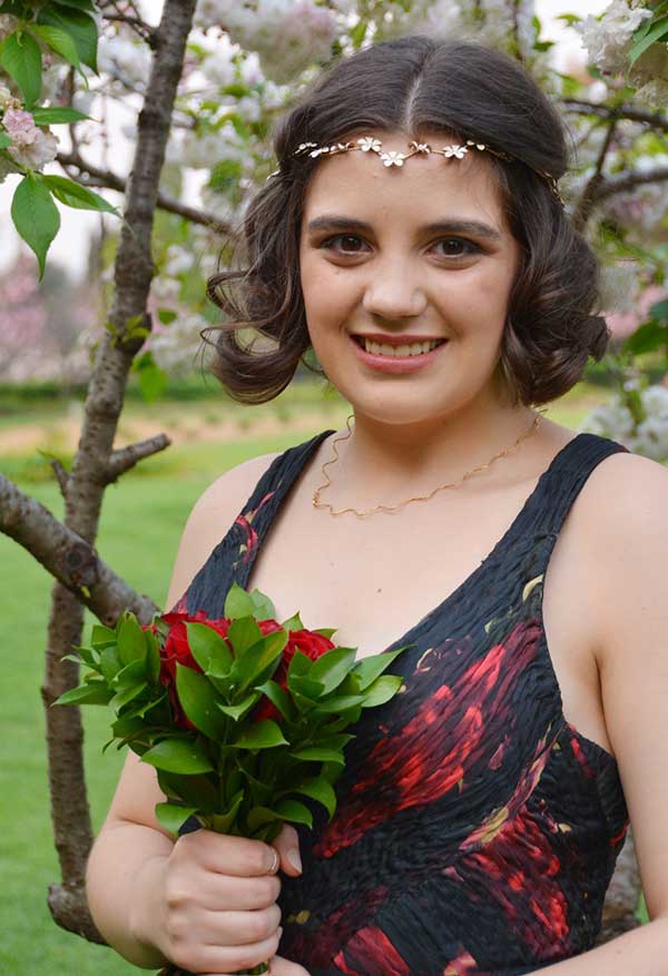 Bride holding red rose bouquet outdoors
