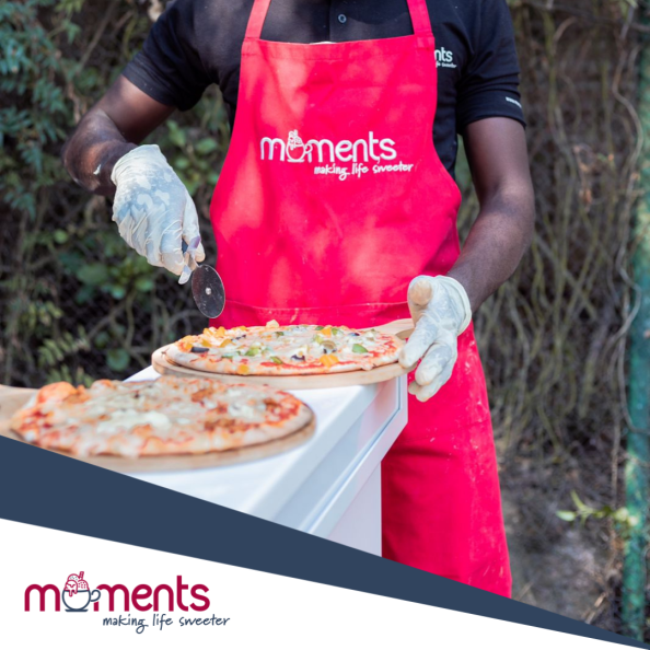 Chef slicing a freshly made pizza outdoors