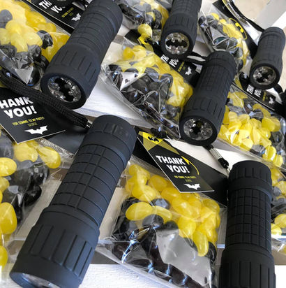 Black flashlights with candy packets and thank you tags