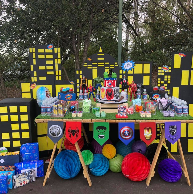 Superhero-themed party setup with decorations and treats