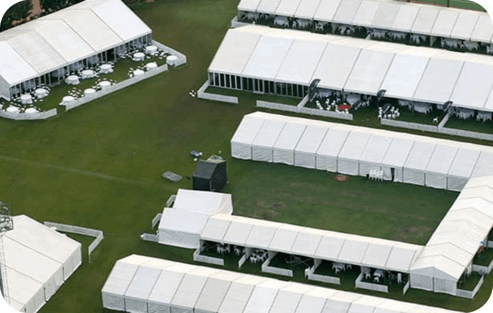 Aerial view of multiple white marquees on grass