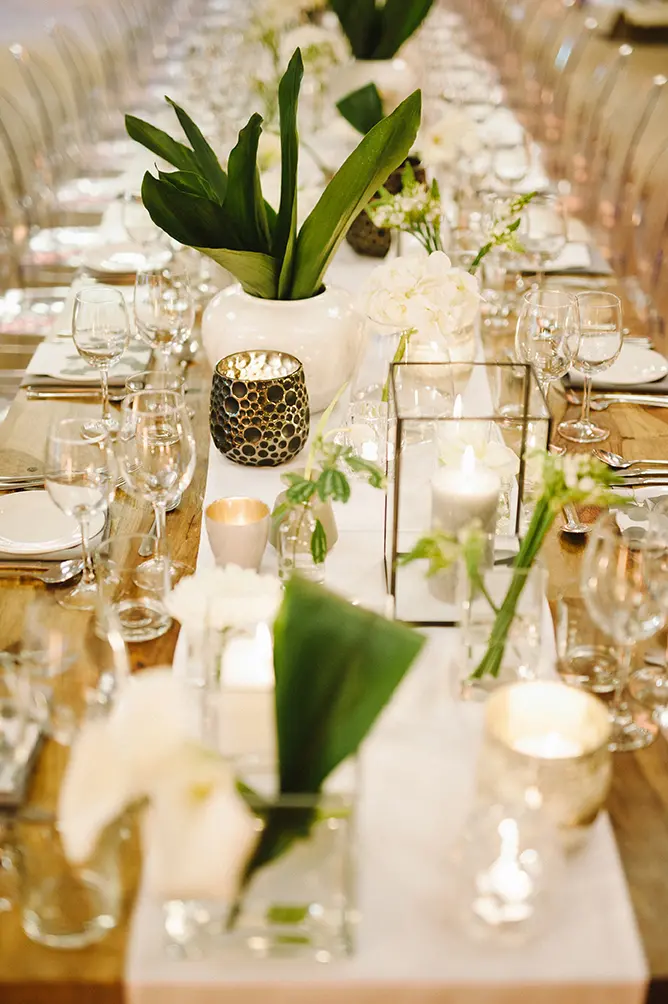 Beautifully styled dining table with floral arrangements and candles.