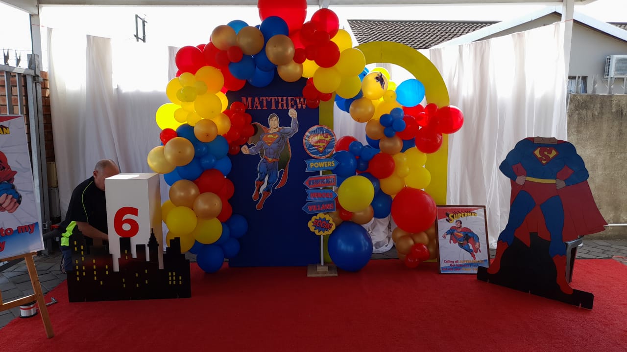 Superhero-themed balloon decoration and backdrop for a kids' party