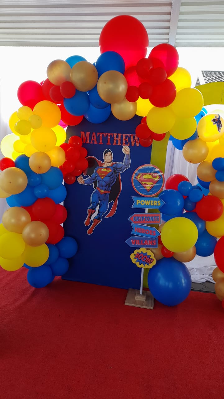 Superhero-themed balloon arch with decorations