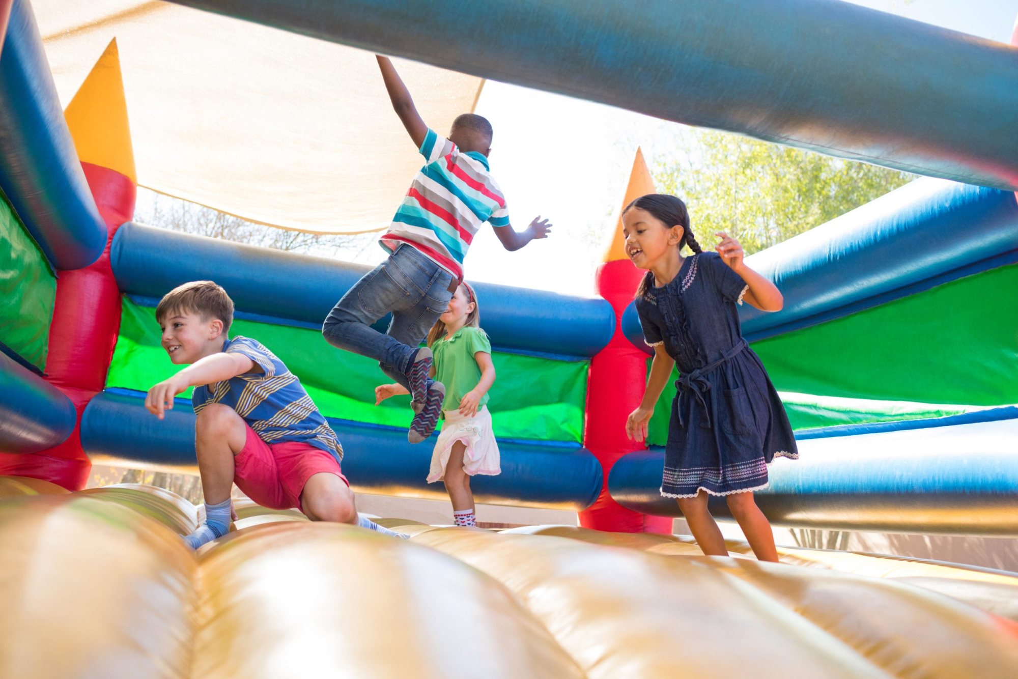 Kids playing and jumping in a colorful inflatable castle