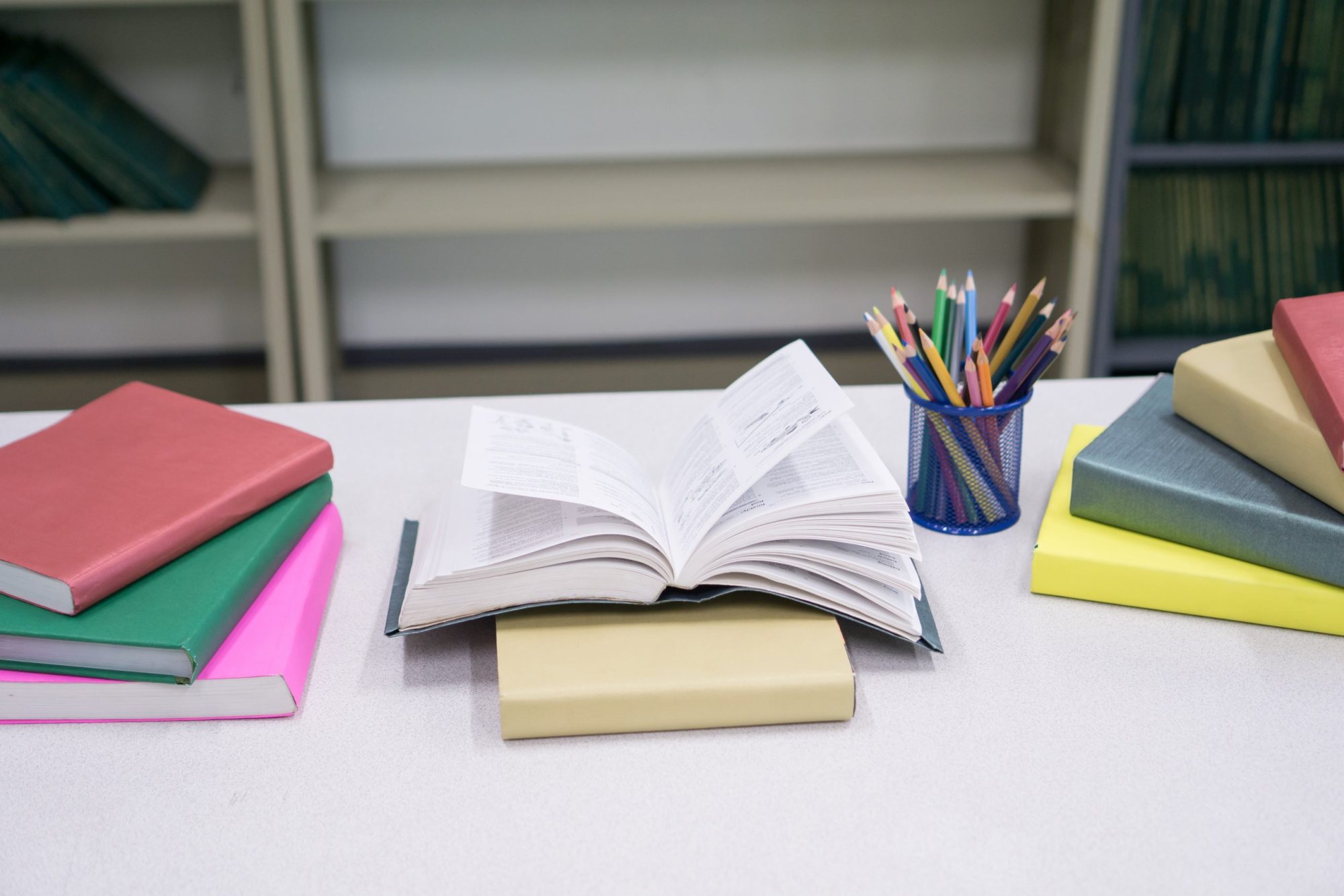 Open book with stationery items and colorful book covers.
