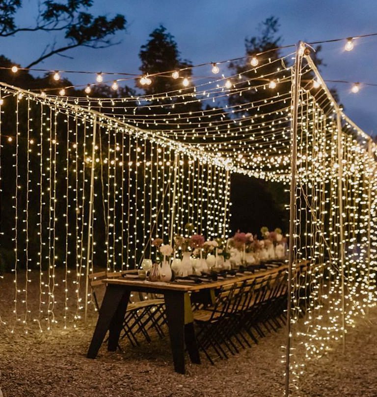 Outdoor fairy lights draped over a dining setup