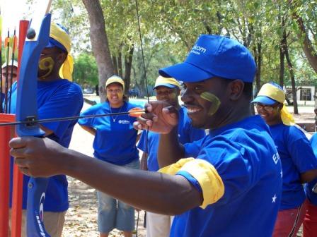 Participants engaged in a team archery challenge outdoors