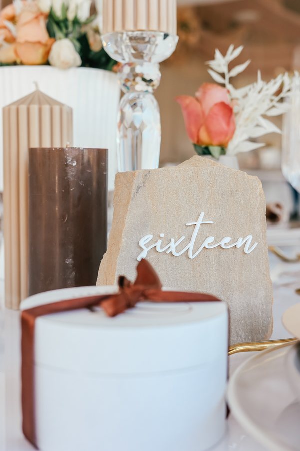 Decorative table setup with candles, flowers, and a number